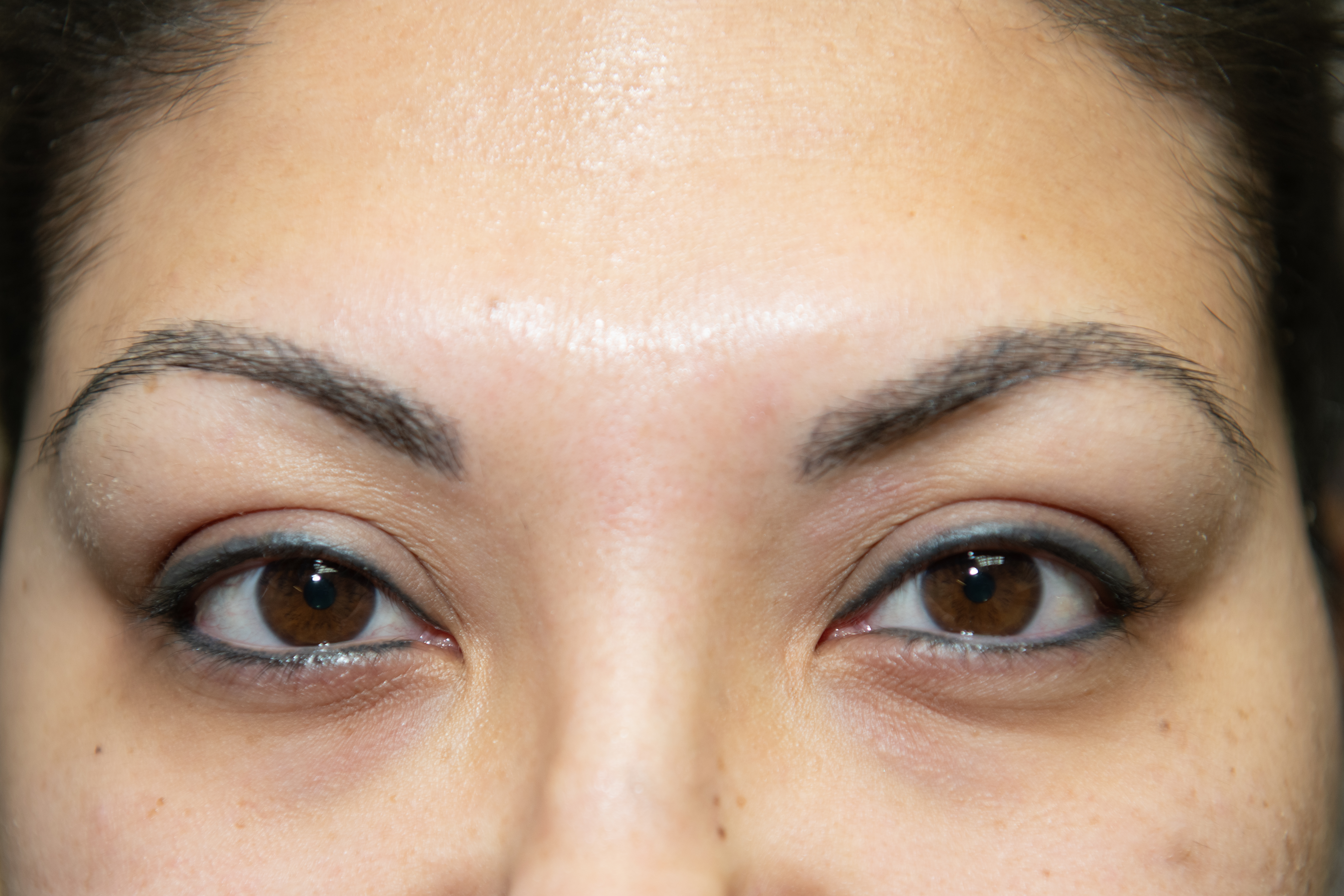 Her eyeliner is already in place but before eyebrows and after brows with brush-like strokes. It is much more permanent and beautiful to tattoo brush strokes than to subject yourself to semi-permanent micro-blading procedures